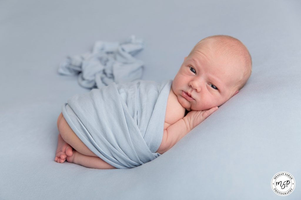 Little Newborn George on a blue background, photoshoot