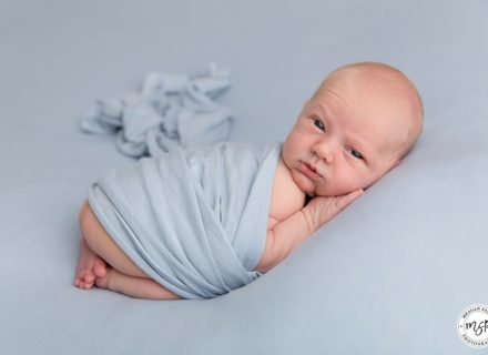 Little Newborn George on a blue background, photoshoot