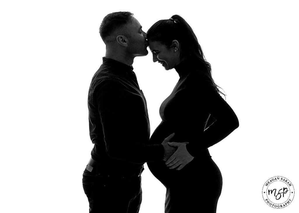 Black and white maternity photo of couple in silhouette
