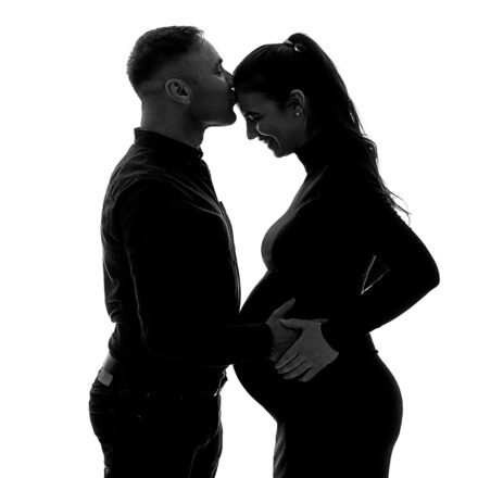 Black and white maternity photo of couple in silhouette