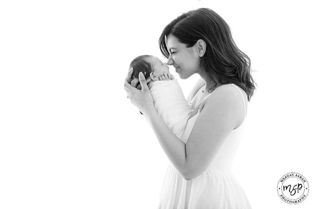 mum and newborn baby girl black and white photo mum holding baby up to face both on profile