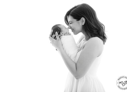 mum and newborn baby girl black and white photo mum holding baby up to face both on profile
