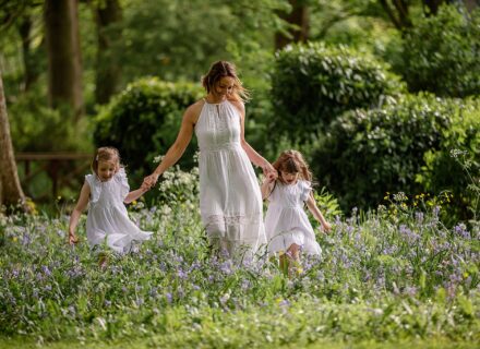 Beautiful image of a mother and her two daughters all in white running through long grass. Photograph taken and Kirkstall Abbey Leeds. Part of our Mummy and Me photoshoot sessions. mini session. outdoor photography.