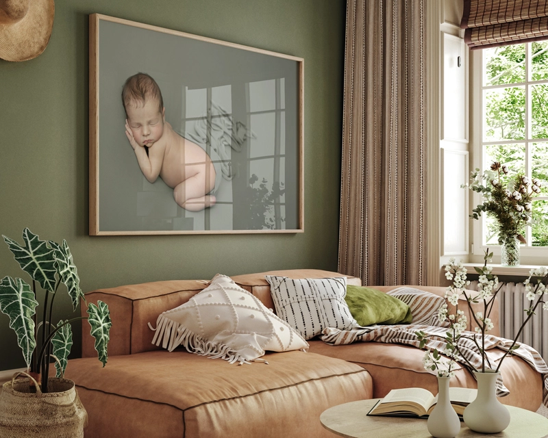 Sample image of newborn photo in large frame on living room wall. Colour scheme green and orange.